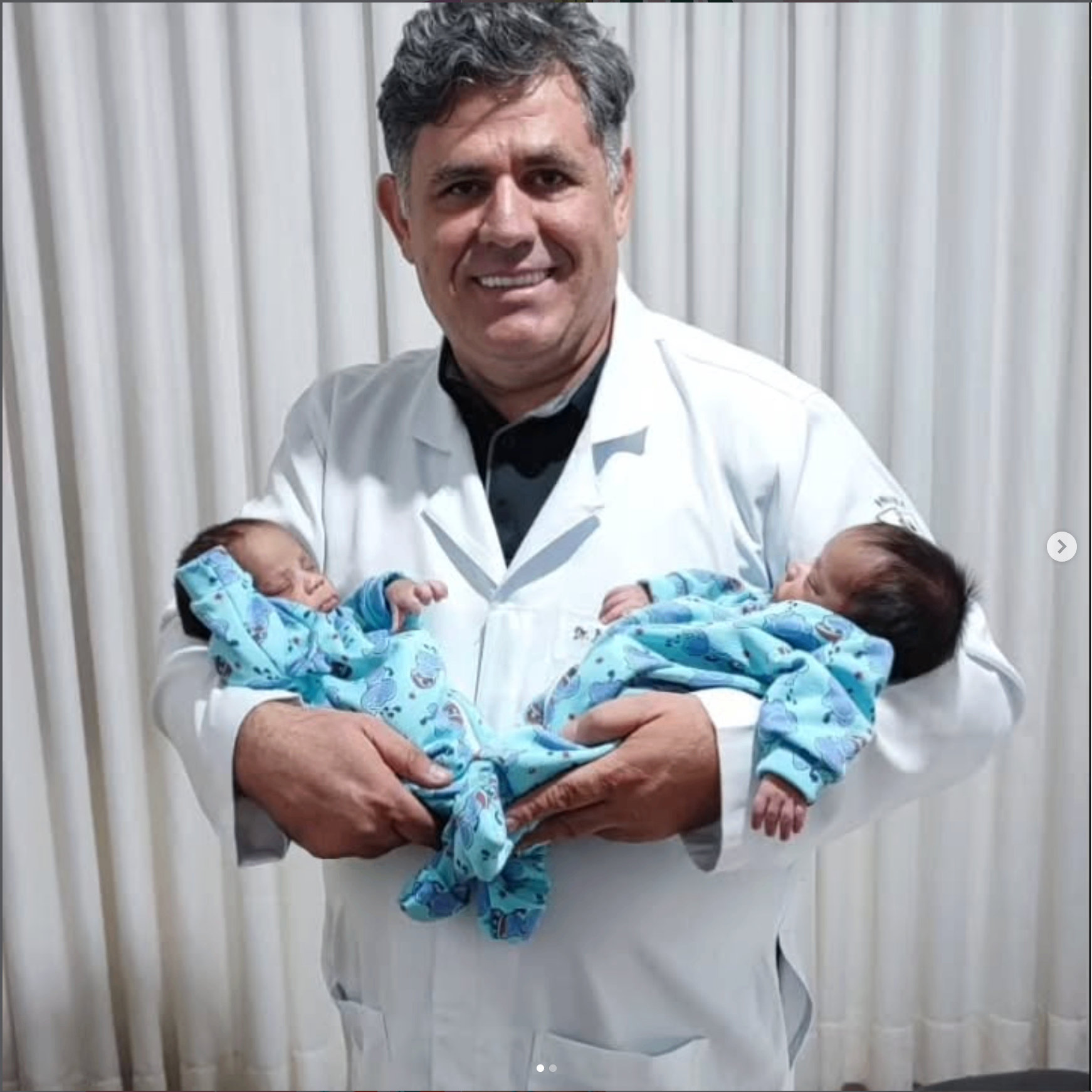 Dr. Juarez Portes, pediatra, segurando dois bebês recém-nascidos